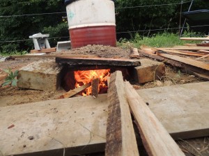 On enfourne le bois au fur et à mesure dans l'alandier pour monter en température.